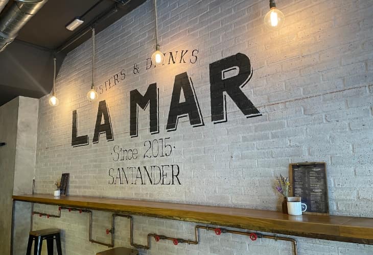 Pared interior de La Mar Oysters & Drinks con el nombre del restaurante destacado, mostrando la decoración y el diseño del espacio